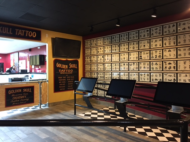 Waiting area with floor-to-ceiling tattoo flash sheets