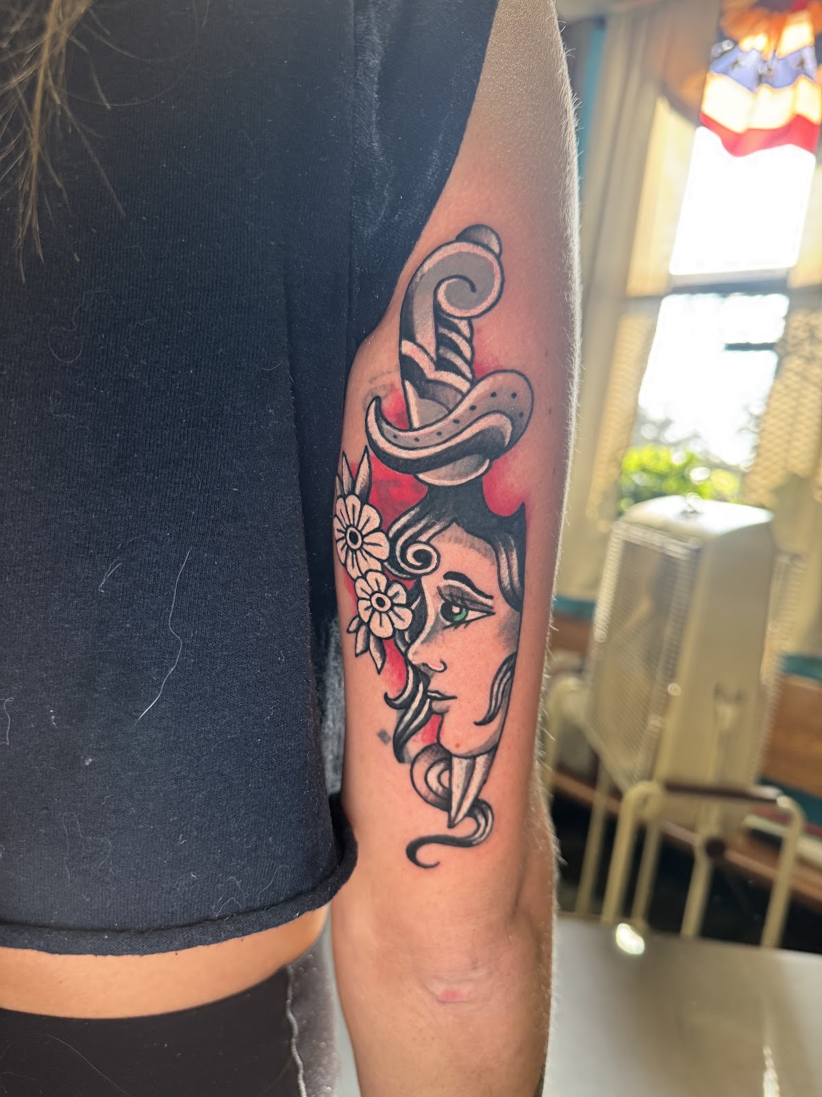 Traditional lady-head dagger tattoo on arm