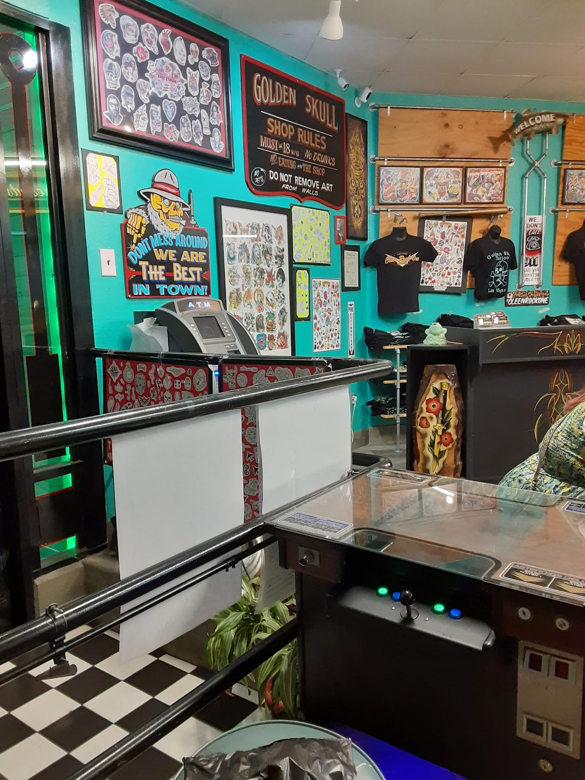 Teal-walled shop interior with artwork and merchandise