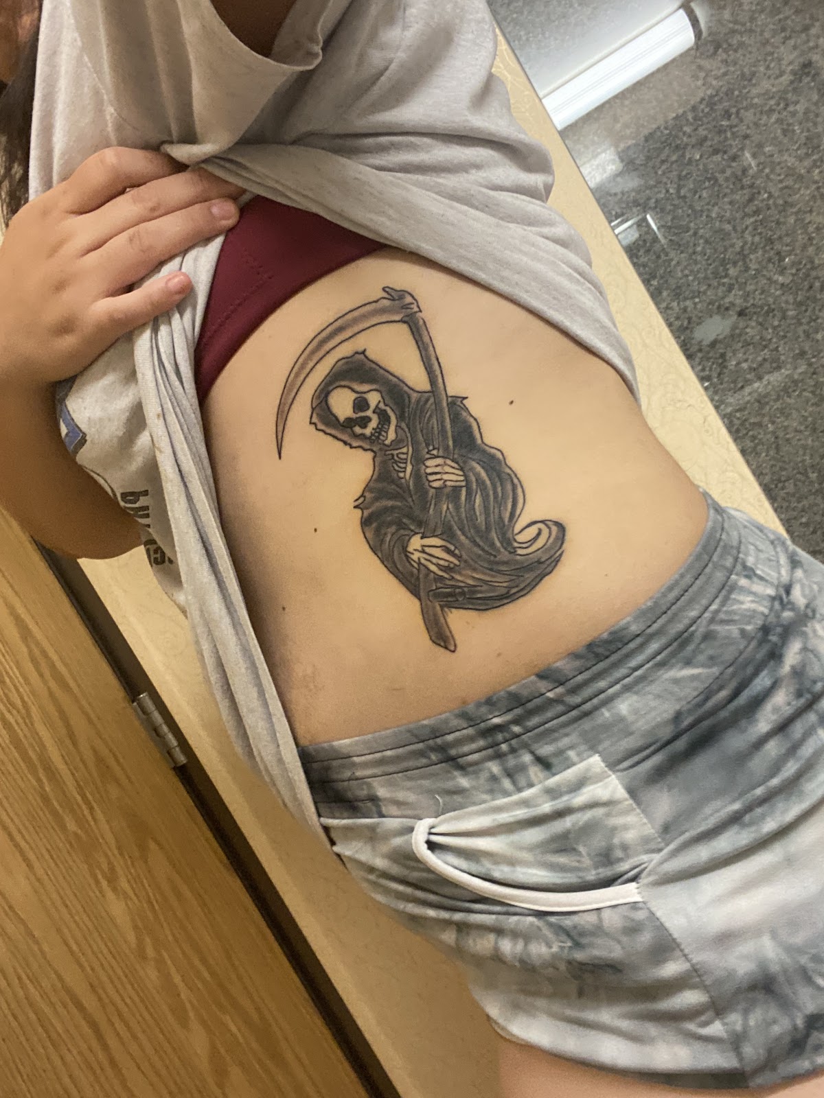Black and grey grim reaper tattoo on ribcage